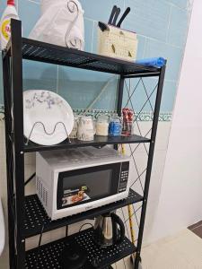 a black shelf with a microwave on top of it at شقة مفروشة في المدينة المنورة- رانونا1 in ‘Urwah