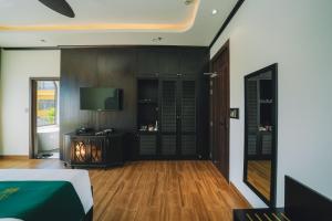 a living room with a bed and a television at Goldient Boutique Hotel in Da Lat