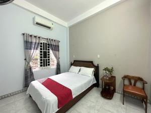 um quarto com uma cama, uma janela e uma cadeira em OYO 1187 Suoi Da Motel em Da Nang