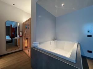 布雷西亞的住宿－Hotel Leonessa，一个带镜子的浴室内的白色大浴缸