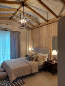 a bedroom with a large bed and a chandelier at Alpine Breeze at Crosswinds Tagaytay in Tagaytay