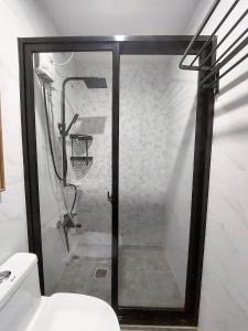 uma cabina de duche em vidro numa casa de banho com WC em Alpine Breeze at Crosswinds Tagaytay em Tagaytay