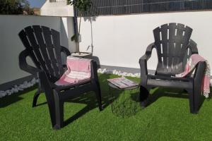 dwa czarne krzesła siedzące na trawie na podwórku w obiekcie Apartamento Loft Jerez Bulería w mieście Jerez de la Frontera