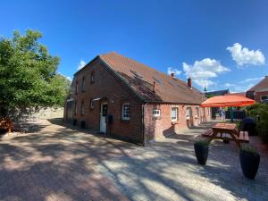 a brick building with a picnic table in front of it at Ferienwohnung Riffgat in Emden
