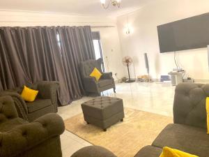 ein Wohnzimmer mit Sofas und einem Flachbild-TV in der Unterkunft SAFARI LAKE VIEW SUITES, KITENDE in Entebbe