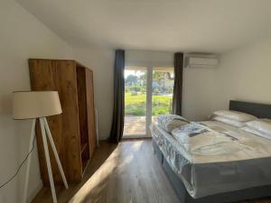 a bedroom with a bed and a lamp and a window at T4 neuf Porto Vecchio Calarossa in Lecci