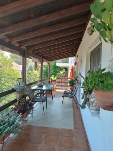 a patio with a table and chairs and plants at Niki Apartments Sea View Attic in Platamonas