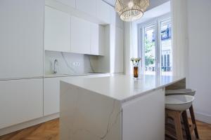 een keuken met witte kasten en een marmeren aanrecht bij Charming Lavapies Center in Madrid