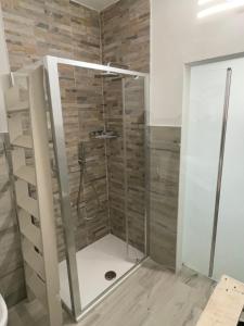 una doccia con porta in vetro in bagno di Holiday House ad Ancona