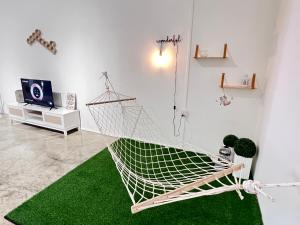a hammock in a room with a green rug at Studio S Conceptual Homestay Station 18 - Ipoh in Ipoh