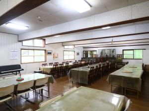 a dining room with tables and chairs and a piano at Narusawaso in Narusawa