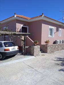 a house with a car parked in front of it at Calma in Perdika