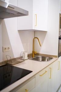 a kitchen with white cabinets and a sink at San Diego Cathedral Sevilla II in Seville