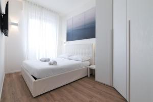 Un dormitorio blanco con una cama y una ventana. en PrimoPiano - Padova 320, en Milán