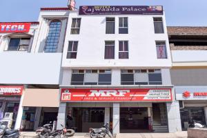 un edificio blanco con motocicletas estacionadas frente a él en OYO Hotel Rajwaada Palace en Bhopal