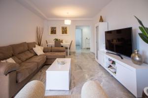 a living room with a couch and a flat screen tv at White dreams next to the sea in Algarrobo-Costa