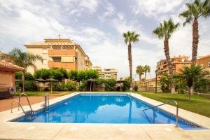 una piscina con palme e edifici di White dreams next to the sea a Algarrobo-Costa