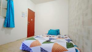 a bedroom with a bed with a quilt on it at West Surabaya Homey in Surabaya