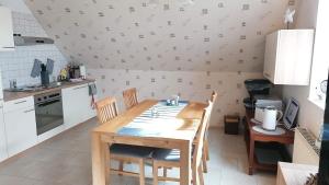 a kitchen with a wooden table and chairs in a room at Ferienwohnung Mangelsen in Gelting