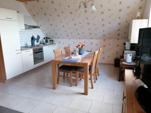 a kitchen with a wooden table and chairs in a room at Ferienwohnung Mangelsen in Gelting