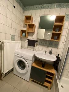 ein Badezimmer mit einer Waschmaschine und einem Waschbecken in der Unterkunft Ferienwohnung Riffgat in Emden