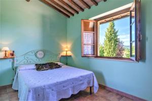 1 dormitorio con cama y ventana en Bazzani Apartments, en Pieve a Scuola