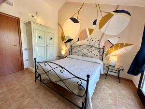 a bedroom with a bed with a painting on the wall at Villa Lotty a 5 minuti a piedi dal mare in Torre delle Stelle