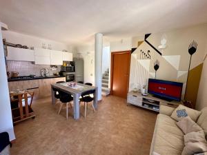 a living room with a table and a kitchen at Villa Lotty a 5 minuti a piedi dal mare in Torre delle Stelle +35 photos