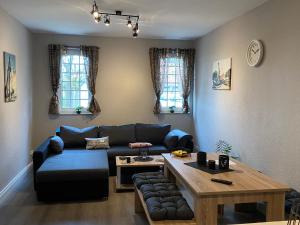 a living room with a blue couch and a table at Ferienwohnung Riffgat in Emden