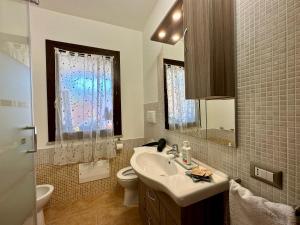 a bathroom with a sink and a toilet and a window at Villa Lotty a 5 minuti a piedi dal mare in Torre delle Stelle