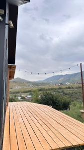 um deque de madeira com vista para as montanhas em Дом в горах Уютный дом с потрясающим видом и огромной террасой em Besqaynar