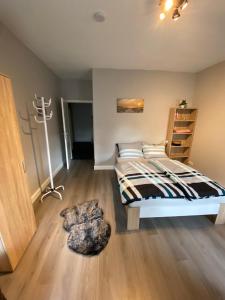 a bedroom with a bed and a wooden floor at Ferienwohnung Riffgat in Emden
