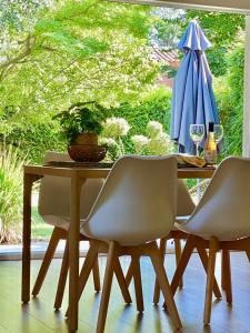 - une table à manger avec 2 chaises et un parasol dans l'établissement Appartement neuf et au calme proche Avignon, à Althen-des-Paluds