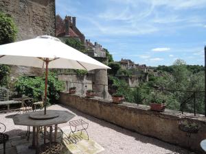 una mesa con una sombrilla blanca en el balcón en La Maison de la Tour en Semur-en-Auxois