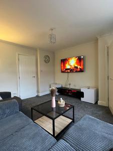a living room with a couch and a tv at The Hideaway by Elegant Apartments in Bradford