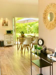 ein Esszimmer mit einem Tisch und einem Sonnenschirm in der Unterkunft Appartement neuf et au calme proche Avignon in Althen-des-Paluds