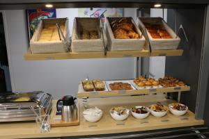 two shelves with different types of pastries on them at Campanile Metz Nord - Woippy in Woippy