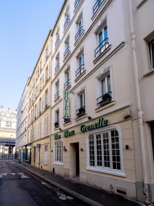 a white building with a sign on the side of it at Hotel Lilas Blanc in Paris