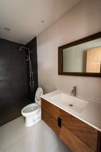 uma casa de banho com um WC, um lavatório e um espelho. em KS villa em San Sai