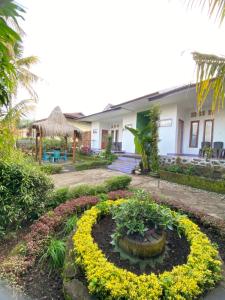 una casa con un giardino fiorito di fronte di Mahoni Guest House a Kelimutu