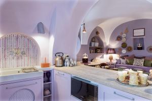 a kitchen with white cabinets and a living room at MOLINO VIOLA in Ceglie Messapica
