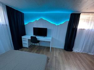 um quarto com uma secretária com um monitor e uma cama em Contemporary Studio + free parking em Klaipėda