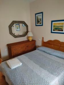 a bedroom with two beds and a mirror at la hacienda in Islantilla