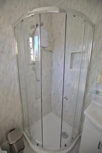 a shower with a glass door in a bathroom at Lewinsdale Lodge in Weston-super-Mare