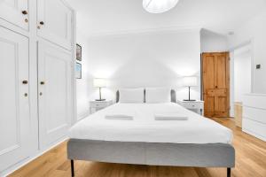1 dormitorio blanco con 1 cama grande y 2 lámparas en Kemptown Coastal By My Getaways, en Brighton & Hove