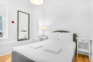 1 dormitorio blanco con 1 cama blanca grande con almohadas blancas en Kemptown Coastal By My Getaways, en Brighton & Hove