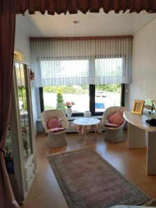 sala de estar con sillas, mesa y ventana en Sunny Hill, en Oberthal