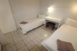 Cette petite chambre comprend deux lits et un bureau. dans l'établissement Seagull 405, à Margate