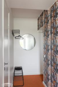a hallway with a mirror and a stool in a room at Hangon Asema 12 in Hanko