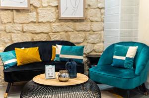 sala de estar con sofá y 2 sillas en Hotel Lilas Blanc en París
